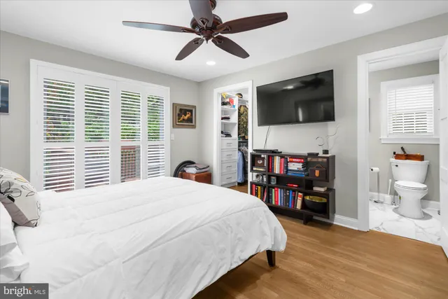 a bedroom with a bed a window and a flat screen television