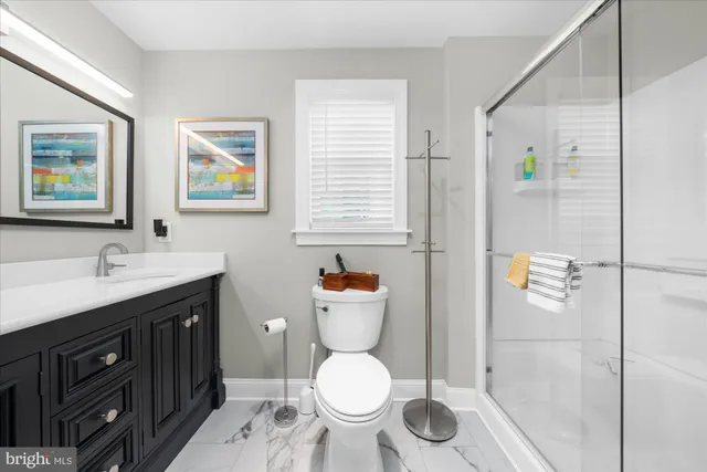 a bathroom with a granite countertop toilet sink and mirror
