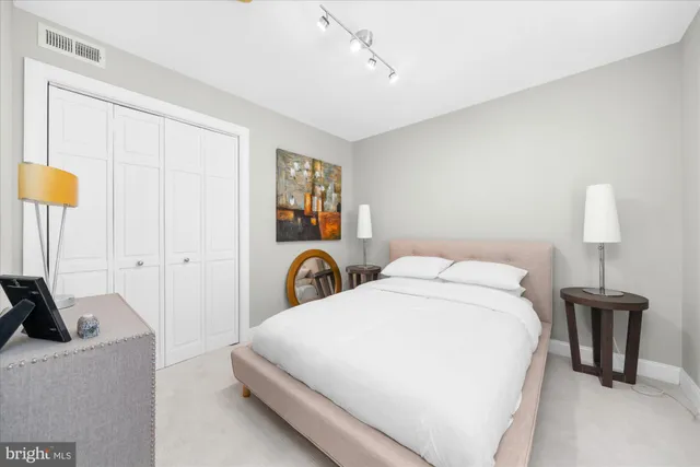 a bedroom with a bed and a lamp on the dresser