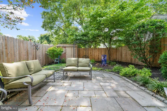 a view of backyard with seating space and wooden fence