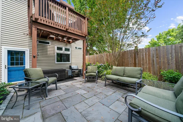a backyard of a house with barbeque oven table and chairs