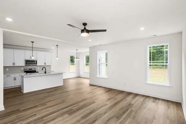 a view of kitchen with stainless steel appliances refrigerator stove microwave and cabinets