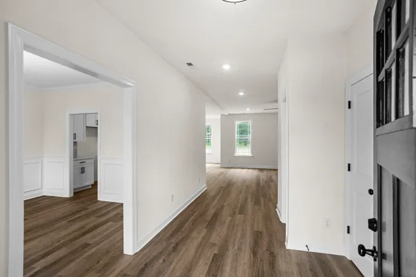 a view of a hallway with wooden floor and closet
