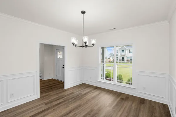 a view of a room with wooden floor staircase and a kitchen