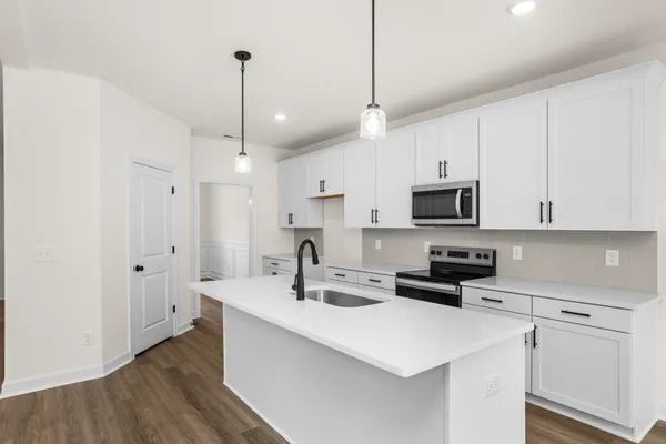a kitchen with a sink a stove a refrigerator and cabinets