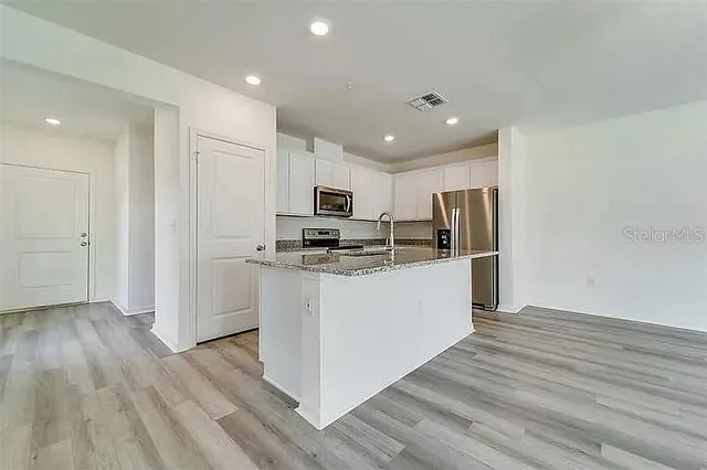 a kitchen with white cabinets and stainless steel appliances