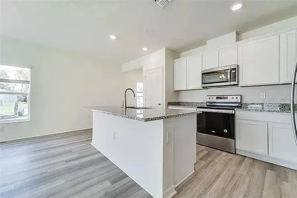 a kitchen with stainless steel appliances granite countertop a stove a sink and a refrigerator