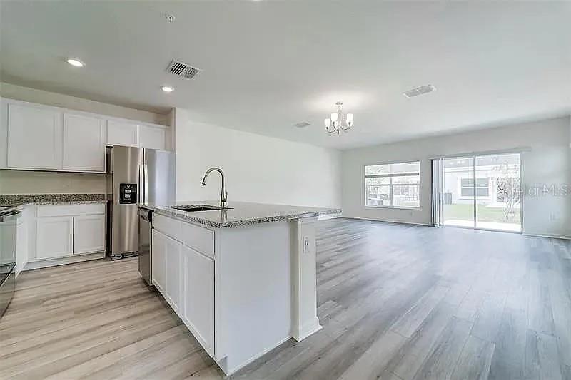 2302 Carrabelle Way Sanford, FL 32771 - Photo 13 of 24 a kitchen with granite countertop a sink and a stove top oven