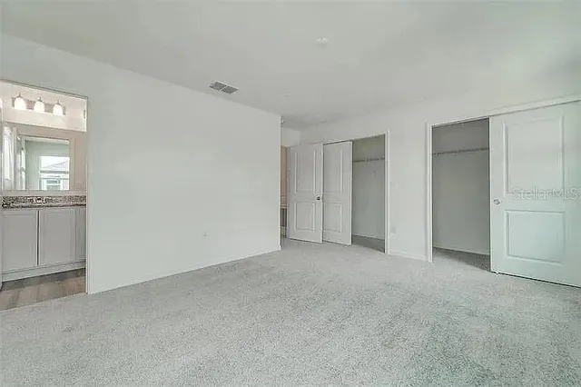 an empty room with windows and closet