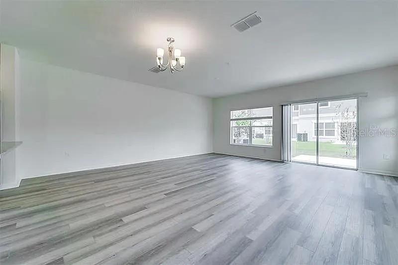 2302 Carrabelle Way Sanford, FL 32771 - Photo 4 of 24 a view of an empty room with a window and wooden floor