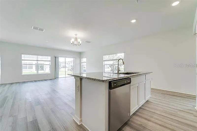 2302 Carrabelle Way Sanford, FL 32771 - Photo 7 of 24 a kitchen with stainless steel appliances granite countertop a stove and cabinets