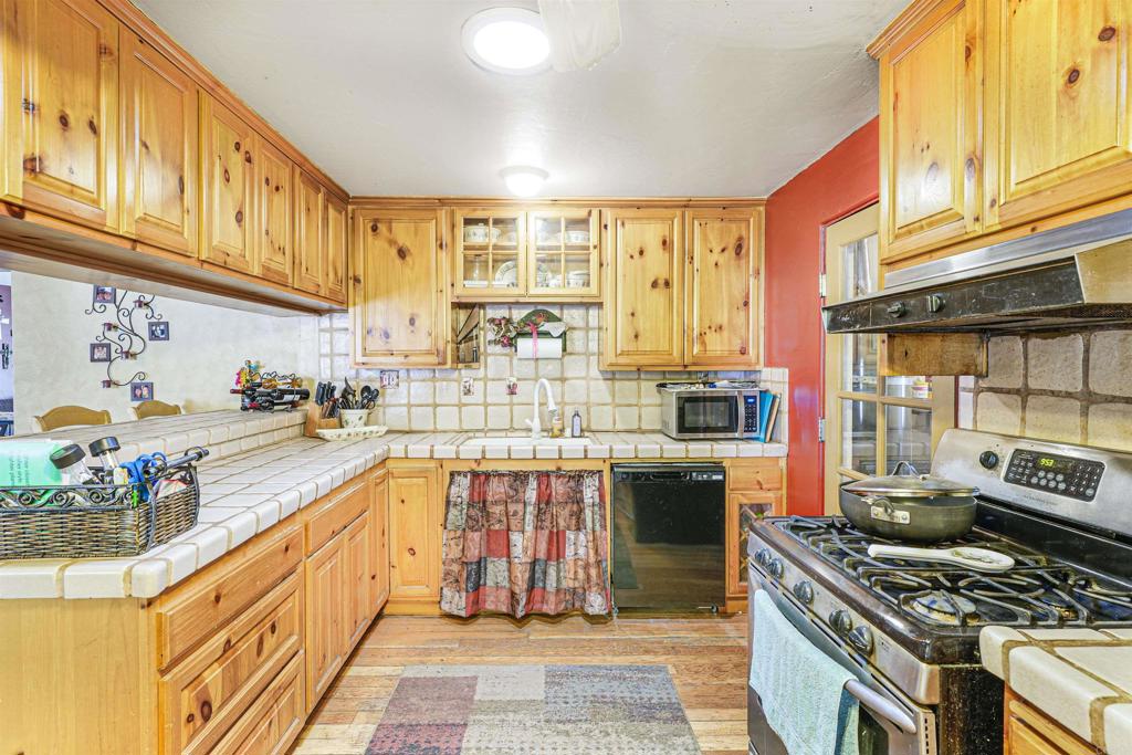 29012 Oak Lane Pine Valley, CA 91962 - Photo 6 of 38 a kitchen with stainless steel appliances granite countertop a stove a sink dishwasher and cabinets with wooden floor
