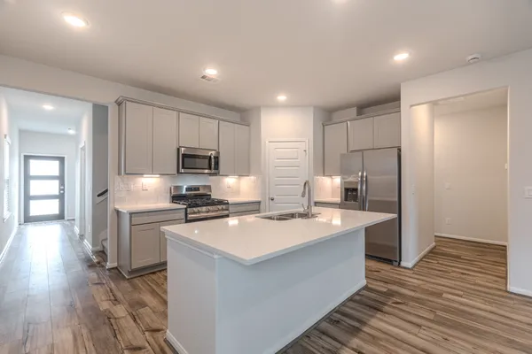a kitchen with stainless steel appliances granite countertop a sink stove and refrigerator