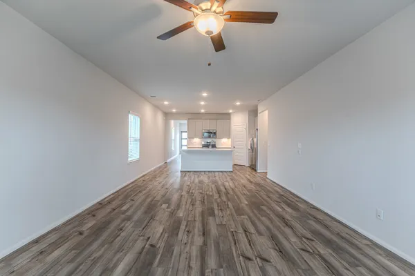 a view of a kitchen with wooden floor and a ceiling fan