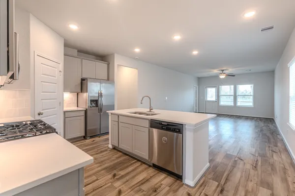 a kitchen that has a lot of cabinets a sink and appliances in it