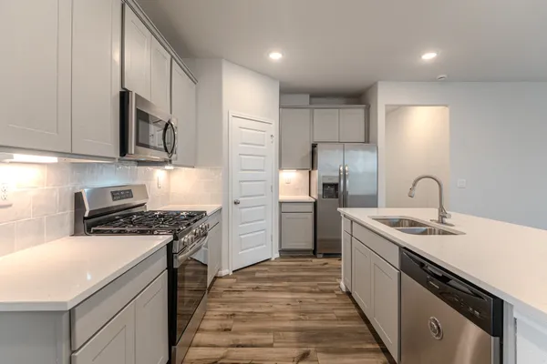 a kitchen with stainless steel appliances granite countertop a sink stove and refrigerator