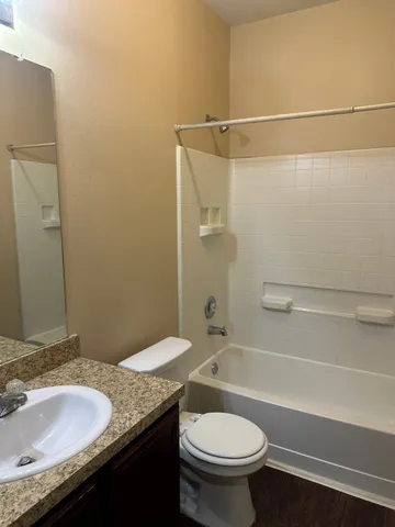 a bathroom with a granite countertop sink toilet and shower
