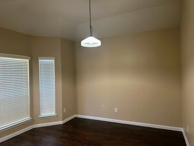 a view of a room with wooden floor and a window