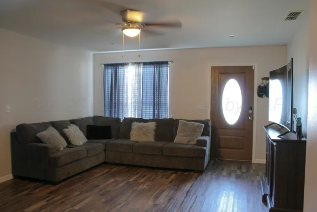a living room with furniture and a wooden floor