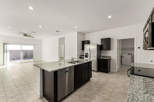 a kitchen with stainless steel appliances granite countertop a stove a sink a refrigerator and a microwave