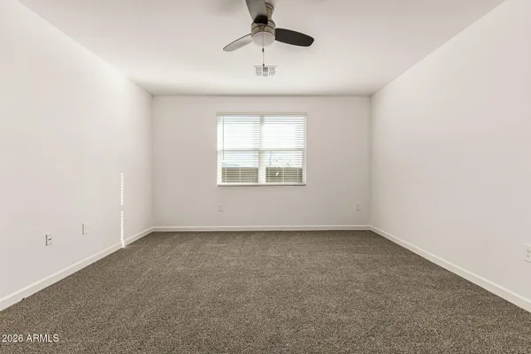 an empty room with a window and a ceiling fan