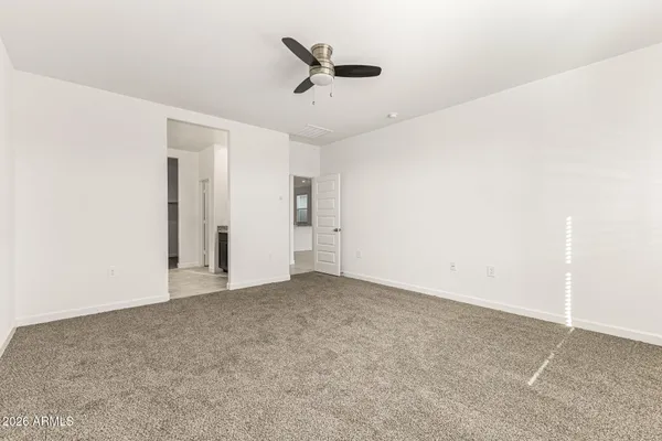 an empty room with closet and ceiling fan