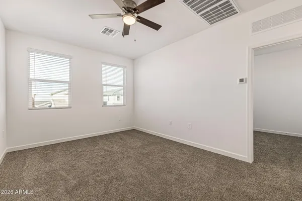 an empty room with windows and fan