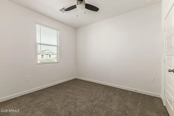 an empty room with a window and a ceiling fan