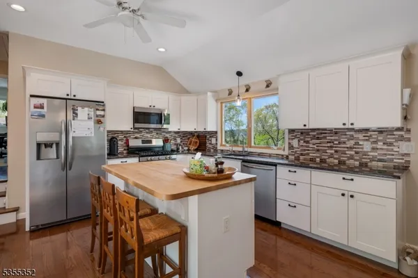 a kitchen with granite countertop a sink appliances cabinets and counter space