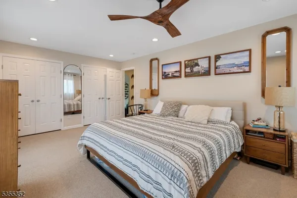 a spacious bedroom with a bed and a lamp