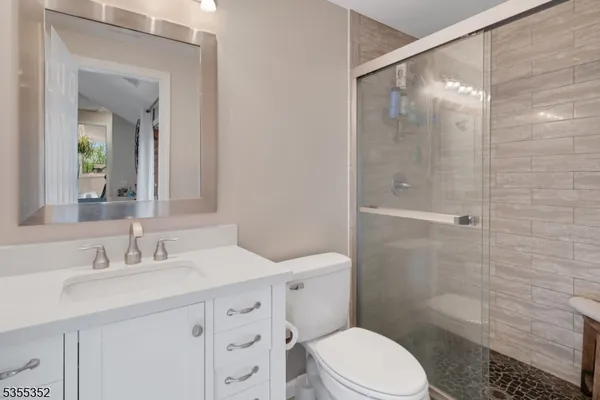 a bathroom with a sink a toilet and shower