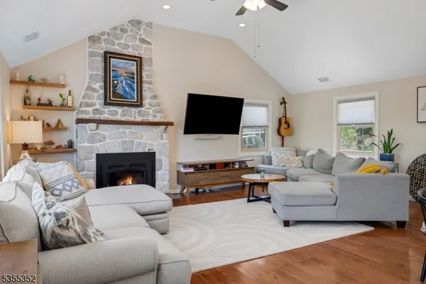 a living room with furniture a flat screen tv and a fireplace