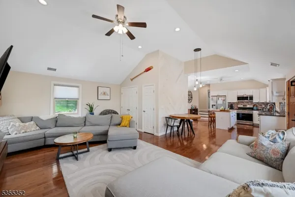 a living room with furniture kitchen view and a window