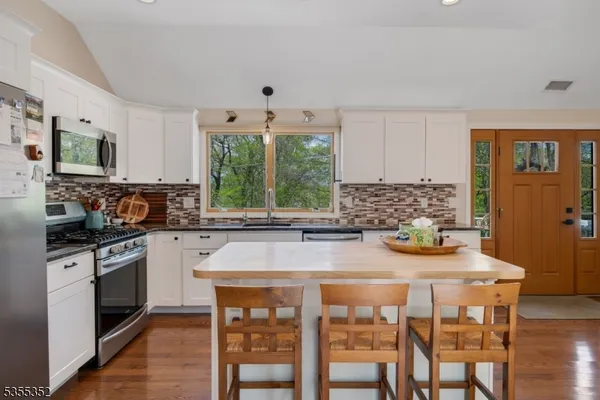 a kitchen with stainless steel appliances granite countertop a stove a sink and a refrigerator