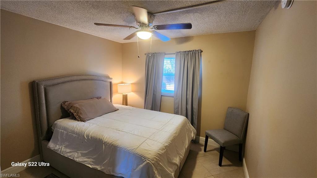 3325 Airport Road North, Unit J3 Naples, FL 34105 - Photo 11 of 13 a bedroom with a bed and a chandelier