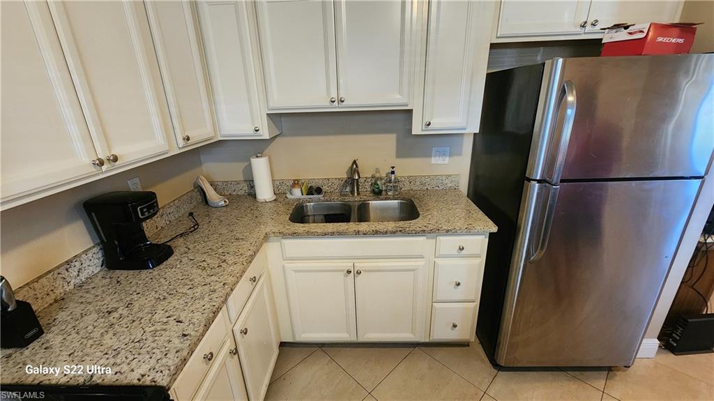 3325 Airport Road North, Unit J3 Naples, FL 34105 - Photo 13 of 13 a kitchen with stainless steel appliances granite countertop a refrigerator a stove a sink and white cabinets