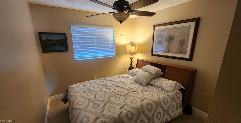 3325 Airport Road North, Unit J3 Naples, FL 34105 - Photo 6 of 13 a bedroom with a bed and a chandelier