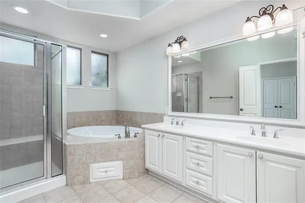 a spacious bathroom with a tub sink and mirror