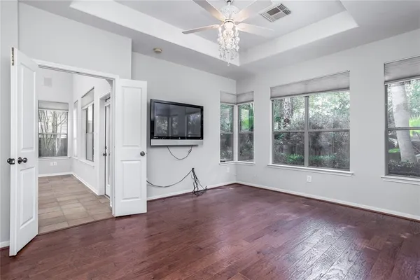 an empty room with wooden floor and windows
