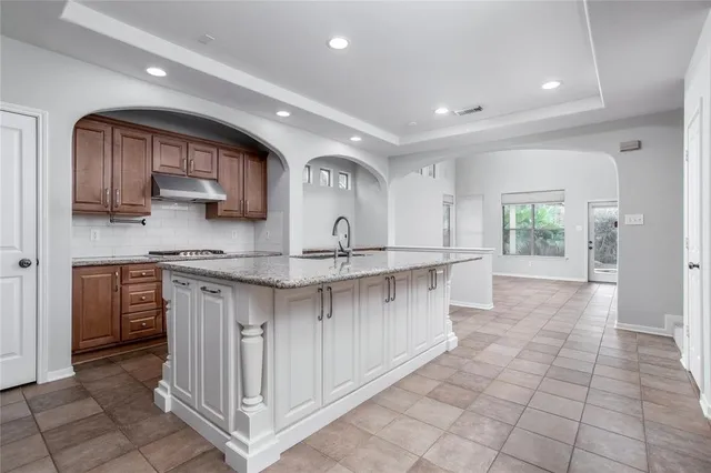 a kitchen with stainless steel appliances granite countertop a sink and a stove