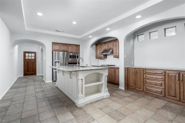 a kitchen with stainless steel appliances a sink and cabinets