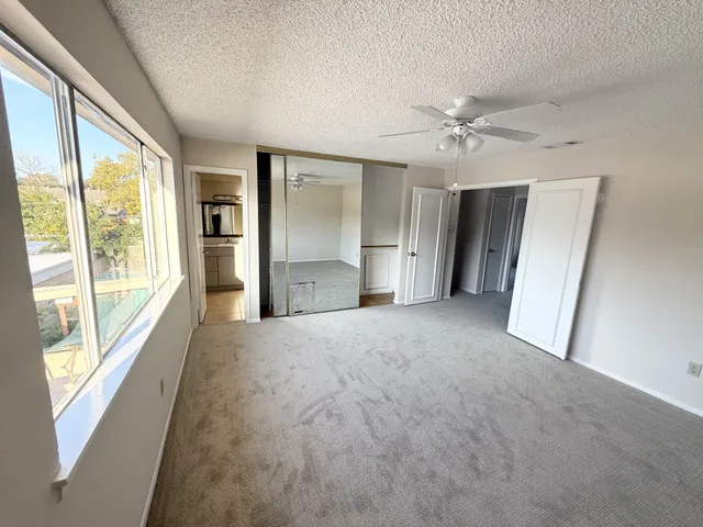 a view of empty room with a ceiling fan and window
