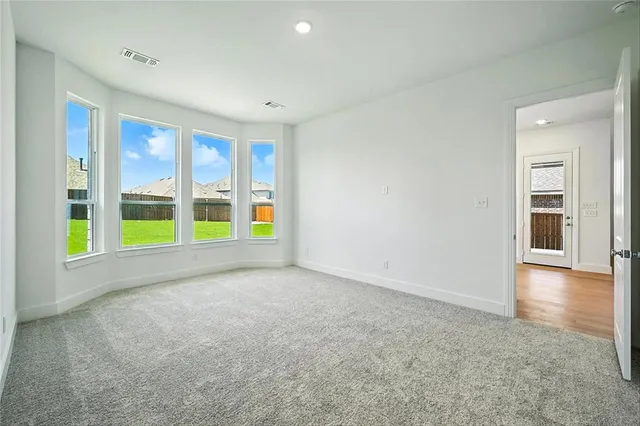 a view of empty room with wooden floor and windows