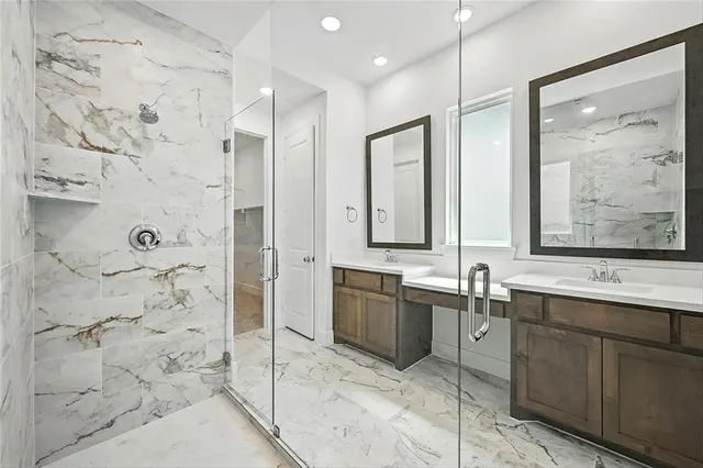 a bathroom with a double vanity sink mirror and shower