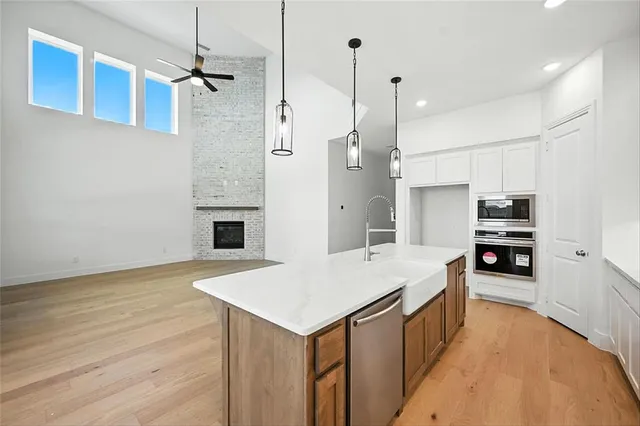 a kitchen with stainless steel appliances a stove refrigerator sink and microwave