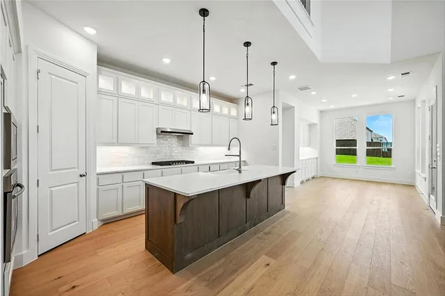 a kitchen with kitchen island a sink stainless steel appliances and cabinets