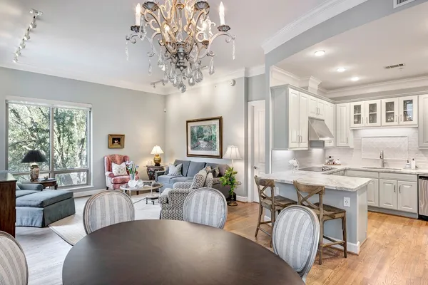 a living room with furniture wooden floor and a chandelier