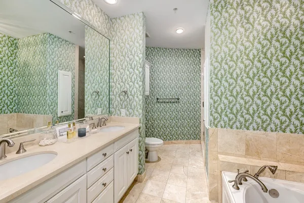 a bathroom with a double vanity sink toilet and shower