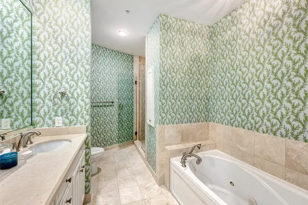 a bathroom with a tub sink and mirror