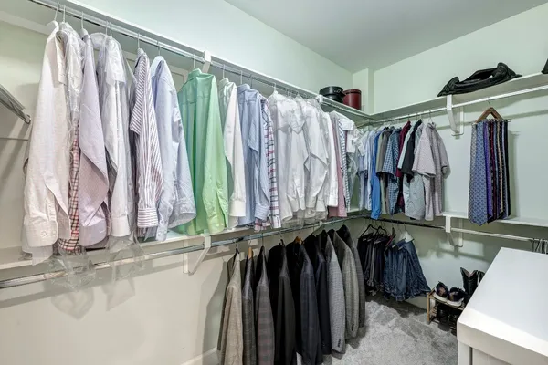 a view of walk in closet with clothes and shoes